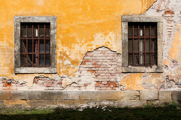 Fototapeta na wymiar old damaged wall with barred windows 3