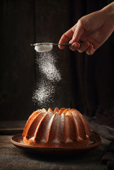 Sprinkling of orange cake with powdered sugar