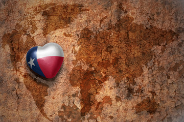 heart with texas state flag  on a vintage world map crack paper background