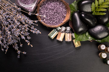 spa concept with stones, flowers , essential oils and mineral salt  on wooden table