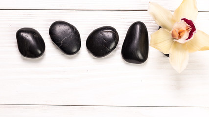 spa concept with stones, flowers , essential oils and mineral salt  on wooden table