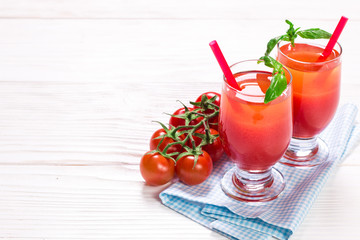 Tomato Juice and Fresh Tomatoes on a White Wooden Background