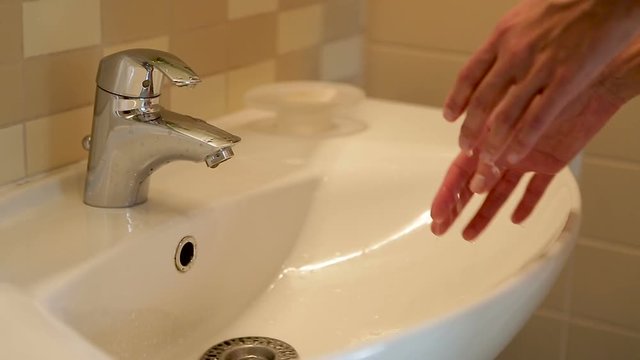 girl washes her hands under the tap