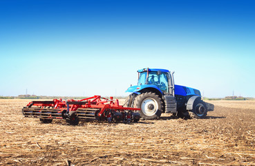 Blue tractor working in an open field