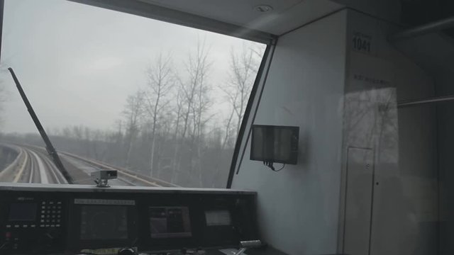 View of subway train operator cabin.  Express train moving fast. View over railroad track.Handheld wide shot