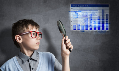 Curious school boy with magnifier