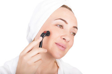 Close up of woman using derma roller. Roller ,microneedle, rejuvenating, beautification, skin care.