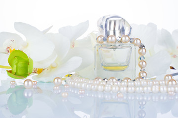 Women's perfume, pearl white beads, jewelry, white orchids. Bottle of perfumes for women. Romantic concept on white background.