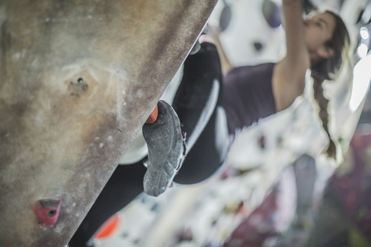 Close up of athlete climbing rock wall in gym - Powered by Adobe