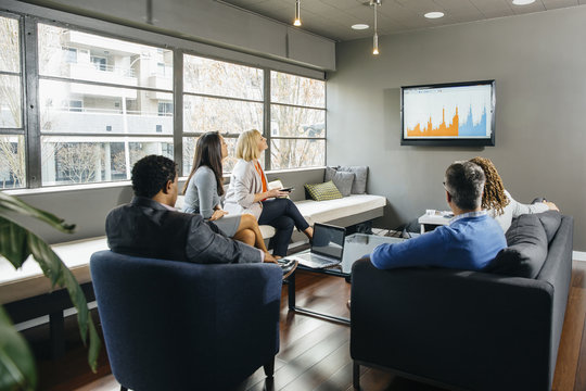 Business people watching presentation in office lounge