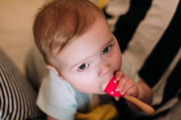 Close-up portrait of a cheerful cute baby in the crib at home