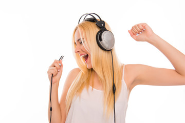 Cheerful lady with mp3 and headphones listening music and singin