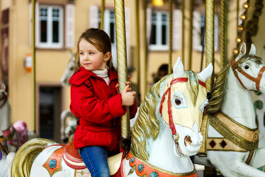 Little girl sitting on carousel horse