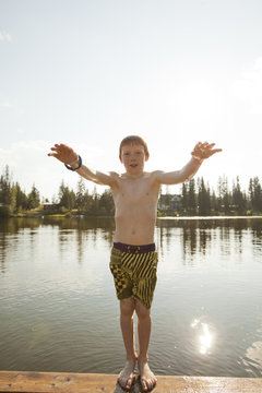 Caucasian boy falling backwards into lake