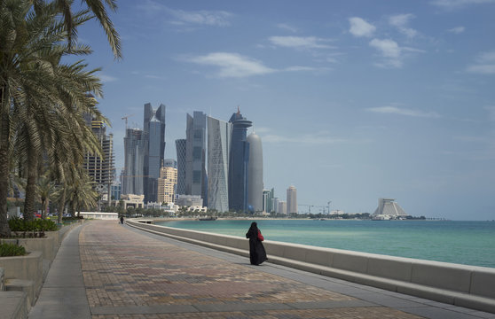 Woman walking on Doha waterfront, Doha, Qatar