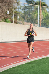 Female distance runner keeping pace on the track.