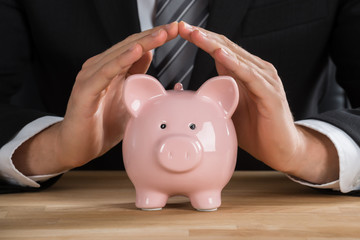 Businessman With Piggybank On Desk