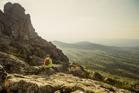 Caucasian hiker walking on rocky hillside in remote landscape