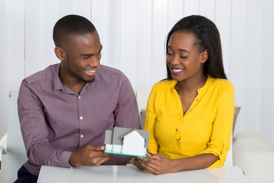 Young Couple Holding A House Model