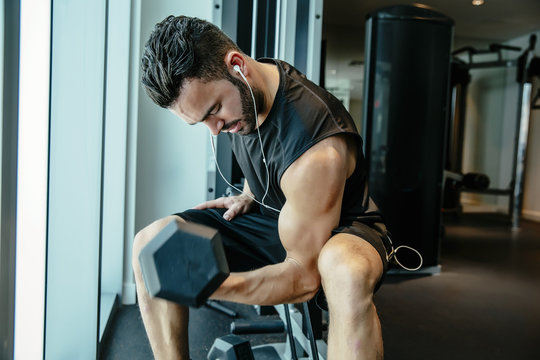 Man Lifting Weights In Gymnasium