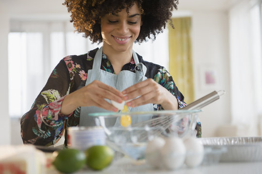 Mixed Race Woman Cracking Egg