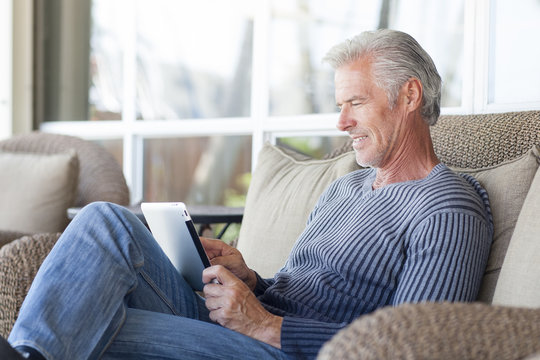 Caucasian man using digital tablet on sofa