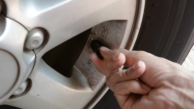 Tire pressure -  shot of car tire pressure being checked.