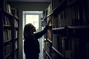 Woman searching for books in library