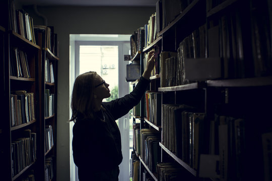 Woman searching for books in library