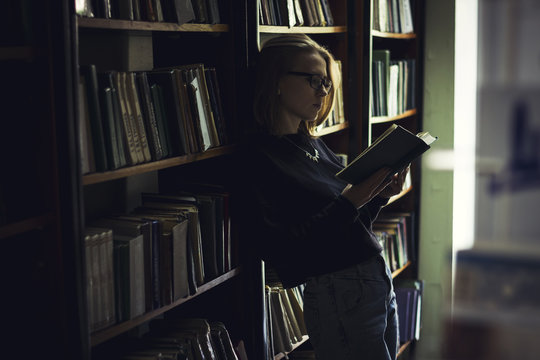 Woman reading book in library