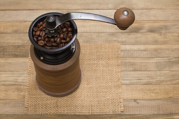 coffee mill full coffee beans on wooden