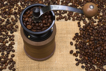 coffee mill full coffee beans on sackcloth