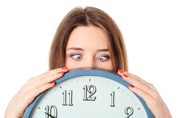Woman holding clock  with wondering eyes foolishly.