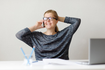 Smiling business woman sitting at office Desk and working with l