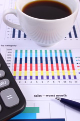 Pen, calculator and cup of coffee on financial graph, business concept