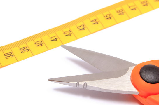 Scissors with tape measure on white background
