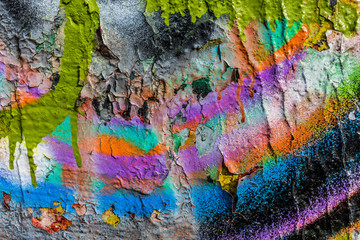 Grungy peeling colorful paint on a concrete wall