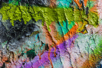 Grungy peeling colorful paint on a concrete wall