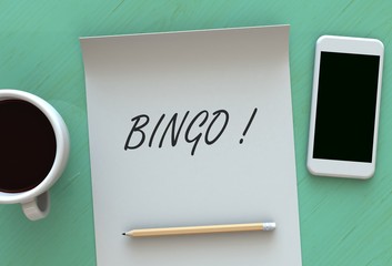 Bingo, message on paper, smart phone and coffee on table, 3D rendering