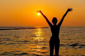 Fototapeta premium Portrait of young woman as silhouette by the sea
