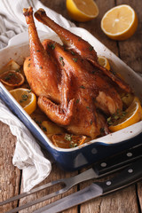 lemon chicken with herbs baked in a baking dish closeup. Vertical
