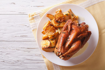 Lemon chicken with potato garnish on a plate. horizontal top view
