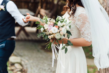 Beautiful wedding bouquet in hands of the bride