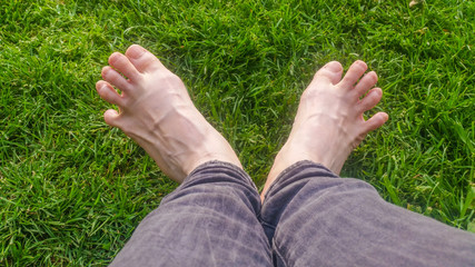 Barefoot on green grass under the sun light