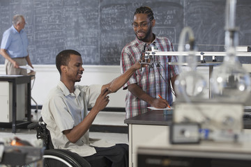 Paraplegic student working with classmate in science classroom