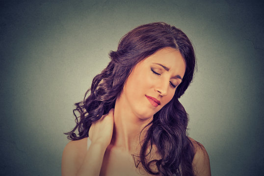 tired woman massaging her painful neck
