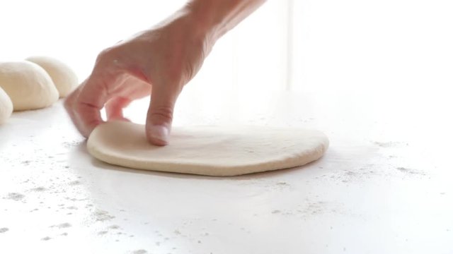 Using wooden rolling pin on handmade dough on table 4K 3840X2160 30fps UHD footage - Rod type roller on hand kneaded dough 4K 2160p UltraHD video 