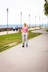 Active young woman rollerskating outdoor.