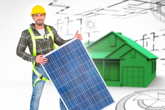 Composite image of smiling handyman with solar panel