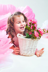 Little girl lying near basket with rose flowers